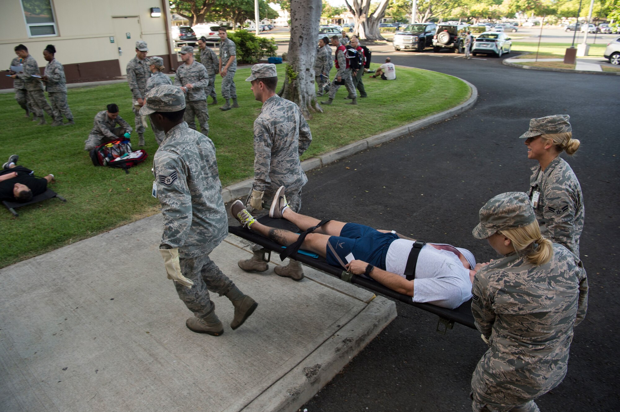Airmen from the 15th Medical Group, work together to carry injured a simulated injured person to a centralized point at the Medical Group, during a mass-casualty scenario for Rim of the Pacific July 12, 2018. Twenty-five nations, 46 ships, five submarines, about 200 aircraft and 25,000 personnel are participating in RIMPAC from June 27 to Aug. 2 in and around the Hawaiian Islands and Southern California. The world’s largest international maritime exercise, RIMPAC provides a unique training opportunity while fostering and sustaining cooperative relationships among participants critical to ensuring the safety of sea lanes and security of the world’s oceans. RIMPAC 2018 is the 26th exercise in the series that began in 1971. (U.S. Air Force photo by Tech. Sgt. Heather Redman)