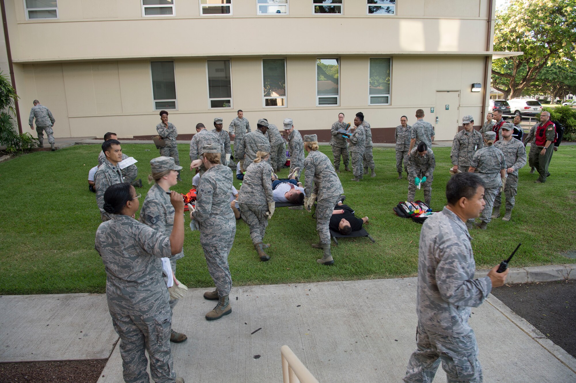 Airmen from the 15th Medical Group work together to provide medical aid for mock casualties during a mass-casualty scenario during the Rim of the Pacific exercise at Joint Base Pearl Harbor-Hickam, July 12, 2018. Twenty-five nations, 46 ships, five submarines, about 200 aircraft and 25,000 personnel are participating in RIMPAC from June 27 to Aug. 2 in and around the Hawaiian Islands and Southern California. The world’s largest international maritime exercise, RIMPAC provides a unique training opportunity while fostering and sustaining cooperative relationships among participants critical to ensuring the safety of sea lanes and security of the world’s oceans. RIMPAC 2018 is the 26th exercise in the series that began in 1971. (U.S. Air Force photo by Tech. Sgt. Heather Redman)