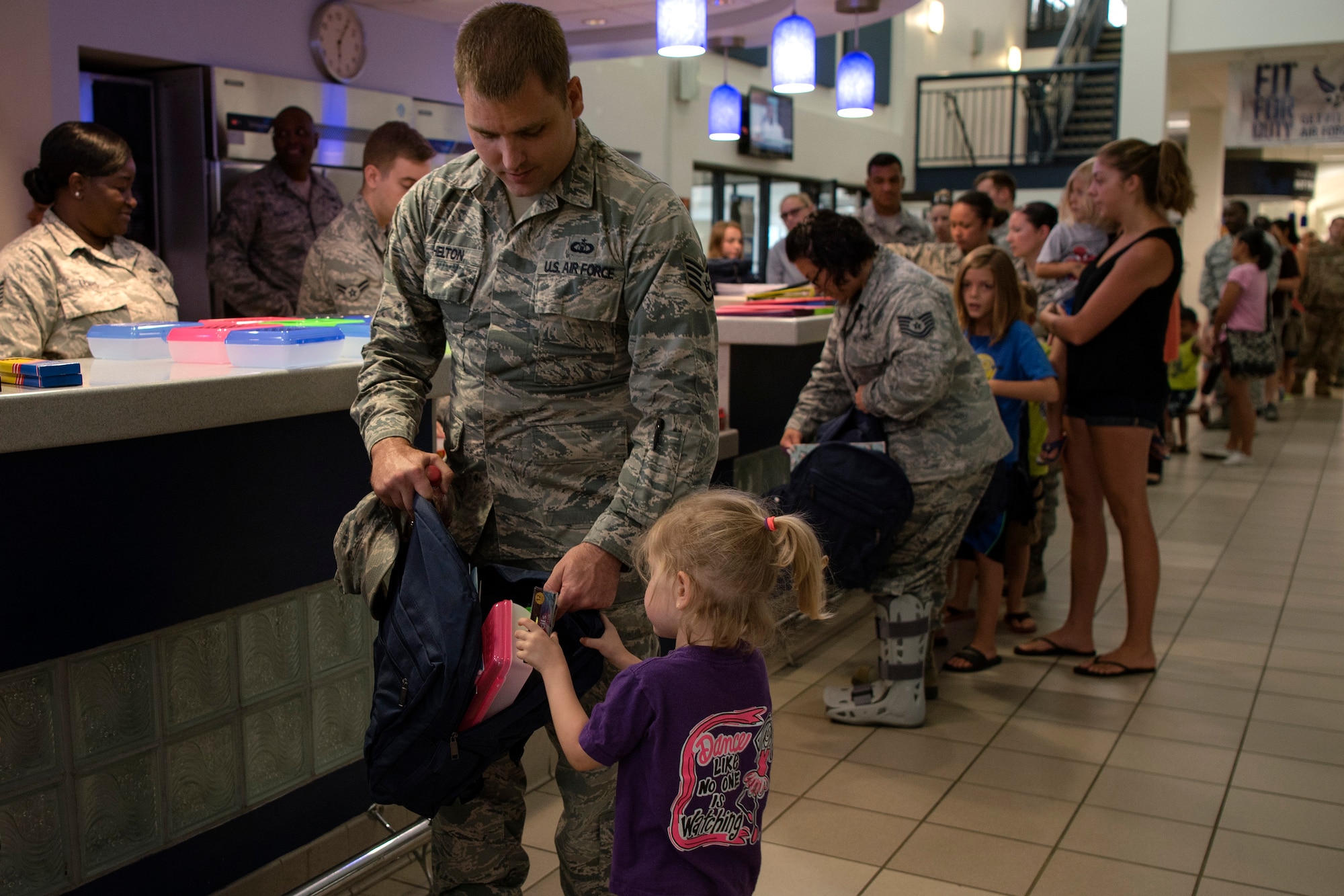 An Airman helps his daughter fill her backpack with supplies at the Back-To-School Brigade, July 25, 2018, at Moody Air Force Base, Ga. With the help of Operation Homefront and the local community, the event provided Moody Airmen, grades E-1 through E-6, with school supplies. (U.S. Air Force photo by Airman Taryn Butler)