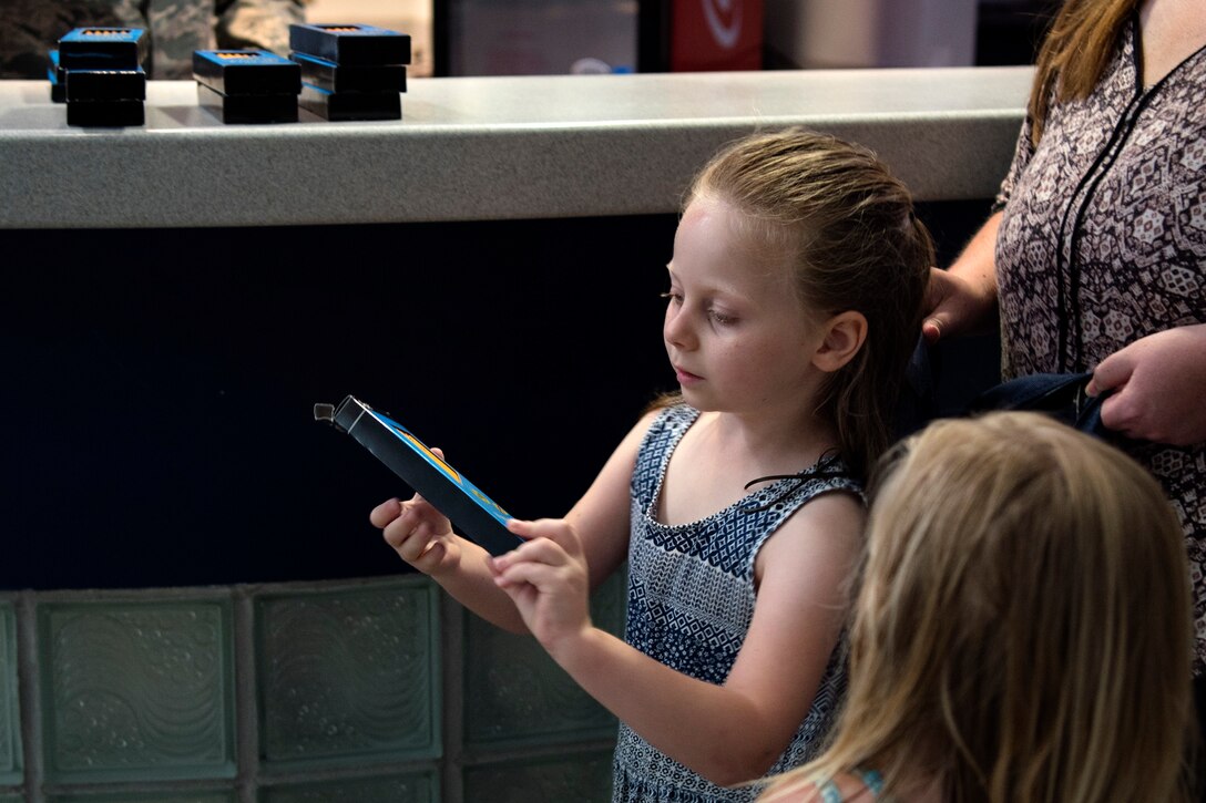 A participant examines pencils at the Back-To-School Brigade, July 25, 2018, at Moody Air Force Base, Ga. With the help of Operation Homefront and the local community, the event provided Moody Airmen, grades E-1 through E-6, with school supplies. (U.S. Air Force photo by Airman Taryn Butler)