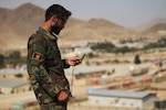 An ANASOC Commando Tactical Air Coordinator (TAC) checks his compass before moving to verify plotted grids during specialized land navigation training near Kabul, Afghanistan, Jul. 16, 2018. Throughout the training, Commandos used different communications platforms to communicate with overhead aircraft during their missions, replicating battlefield scenarios. This multi-faceted communications approach enables Commandos to orchestrate kinetic close-air strikes and casualty evacuation with surgical precision.