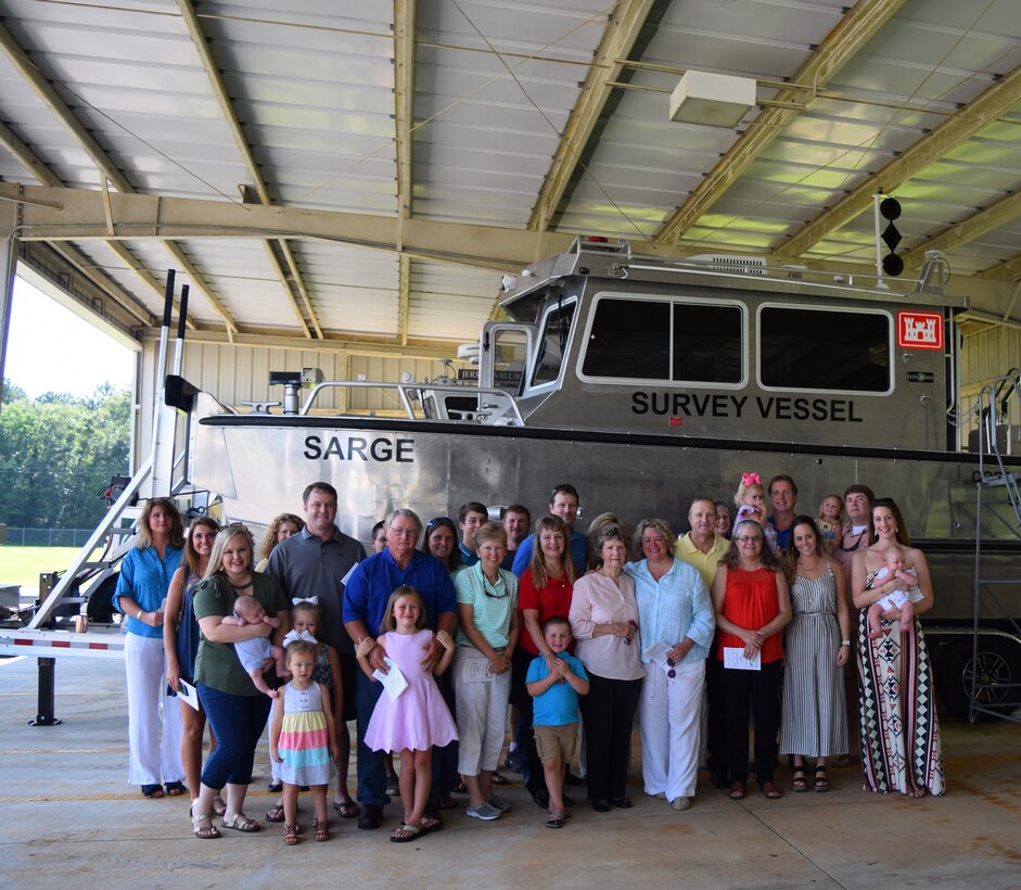 Members of former Irvington Site employee Stephen Sema’s family pose in front of the Sarge, a new survey vessel during a christening ceremony July 13, 2018, in Irvington, Ala.