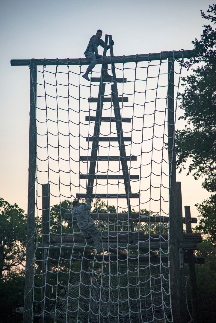 Security Forces Airmen climb and obstacle July 23, 2018, at Joint Base San Antonio-Camp Bullis, Texas in preparation for the 2018 Defender Challenge. The competition will pit security forces teams against each other in realistic weapons, dismounted operations and relay challenge events. (U.S. Air Force photo by Senior Airman Stormy Archer)