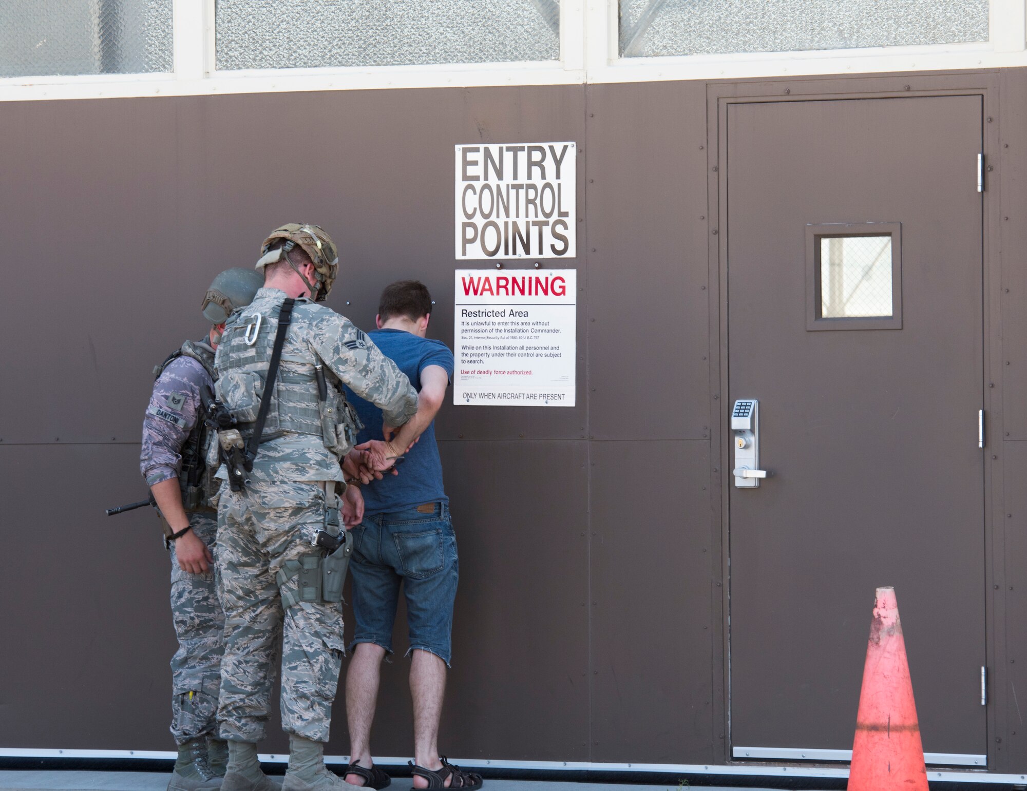 Members of the 366th Security Forces squadron release Airman 1st Class Trevor Gordnier, 366th Fighter Wing broadcast journalist, from handcuffs during a Force Protection Condition exercise, July 23, 2018, at Mountain Home Air Force Base, Idaho. The exercise tested the wing’s ability to execute the proper procedures associated with different FPCONs during a wide variety of scenarios.(U.S. Air Force photo by Airman 1st Class Alaysia Berry)