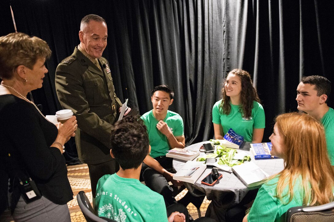 The chairman of the Joint Chiefs of Staff and his wife speak with students.