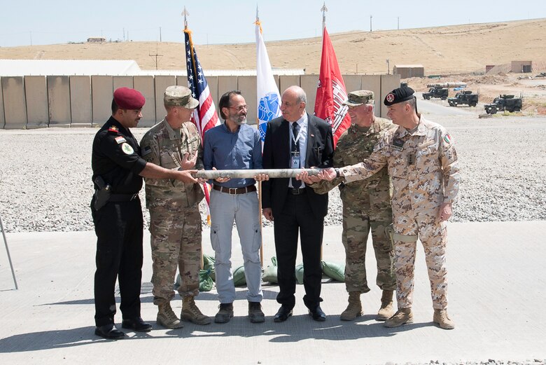 Representatives of each partner on the Mosul Dam stabilization project hold a core sample representing the mutual goal of stabilization. From left, Col. Muntadar, Iraq; Col. Mike Farrell, outgoing Commander, Mosul Dam Task Force; Mr. Miconi, Project Manager,Trevi; Mr. Riyadh, Iraq Ministry of Water Resources; Col. Philip Secrist, Commander, Mosul Dam Task Force; and Col. Settesoldi, Commander, Task Force Presidium.