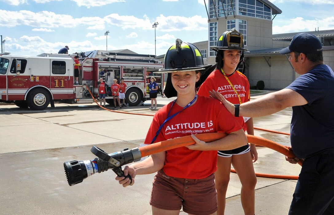 Dakota Wagner (Left) and Savannah Smith (Center) learn what it's like to be a firefighter during their second day of Air Camp at Wright-Patterson Air Force, Ohio. July 17, 2018.