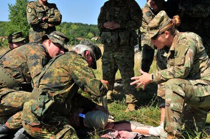 U.S. Army Maj. Amanda Young, a flight surgeon assigned to 1st Battalion, 376th Aviation Regiment, Nebraska Army National Guard, helps train German Bundeswehr Reserve soldiers on medical air evacuation at the Joint Multinational Readiness Center's Hohenfels training area, Hohenfels, Germany, July 19, 2018. Nebraska and North Dakota Army National Guard Soldiers are participating in multinational interoperability training, which enhances the working relationship between the U.S. and the host nation.