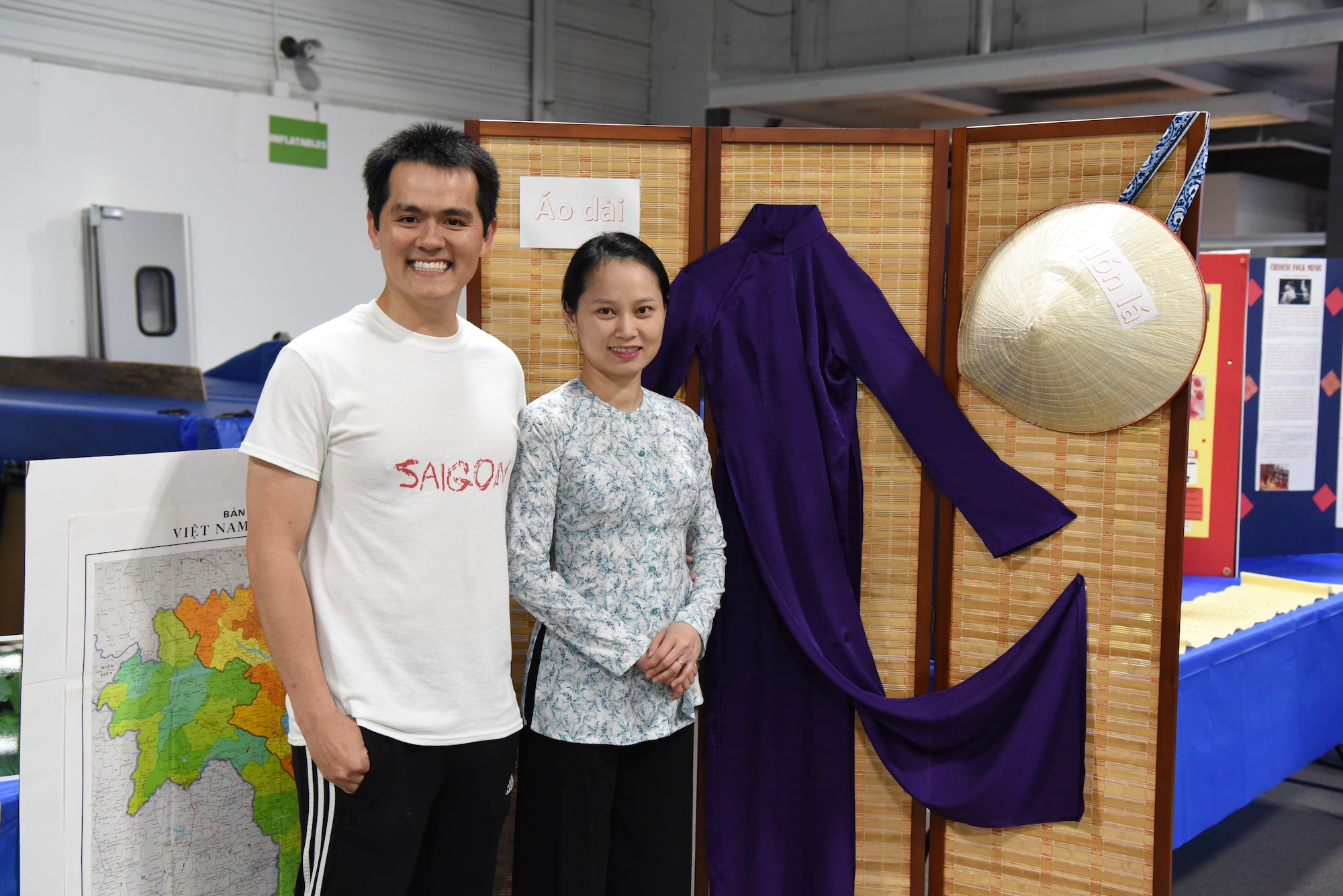 Airman 1st Class Luan Tong, a 319th Comptroller Squadron financial operations technician, and his wife, Linh Le, pose for a photo June 20, 2018, at Grand Forks Air Force Base, North Dakota. Tong said his booth was based on Vietnam culture, where he showed base residents clothing styles, tea sets and a food dish from his native country. (U.S. Air Force photo by Airman 1st Class Melody Wolff)