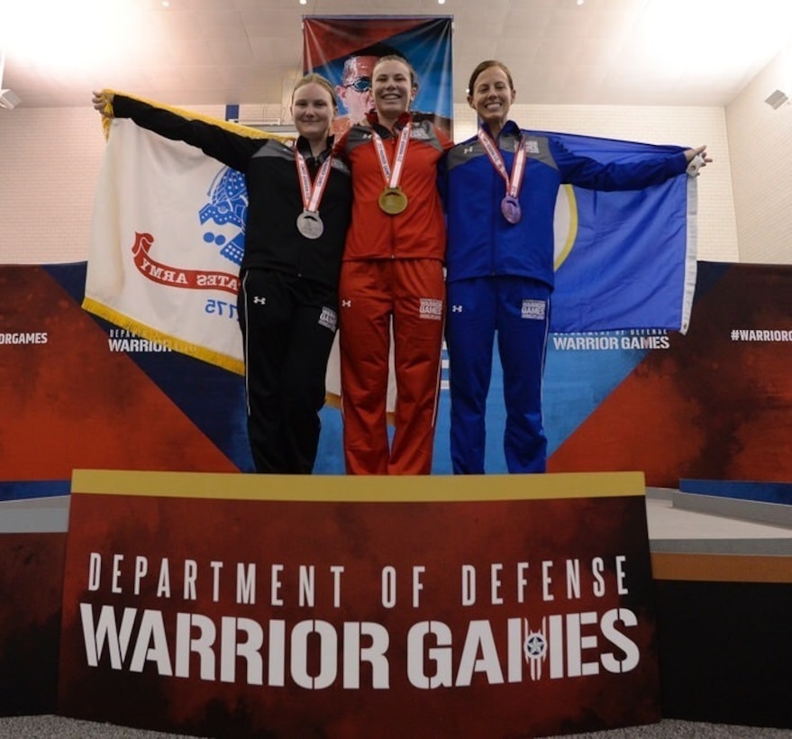 Cpl. Kira R. Lavine, center, with Marine Air Support Squadron 3, Marine Air Control Group 38, 3rd Marine Aircraft Wing, receives a gold medal in the 50-meter freestyle swimming competition.  The Warrior Games took place June 1-9 at the U.S. Air Force Academy in Colorado. Competitors ranged from a Paralympic-style competition for wounded to injured service members from all U.S. branches of service, and this year includes teams from the United Kingdom Armed Forces, Australian Defence Force and Canadian Armed Forces.