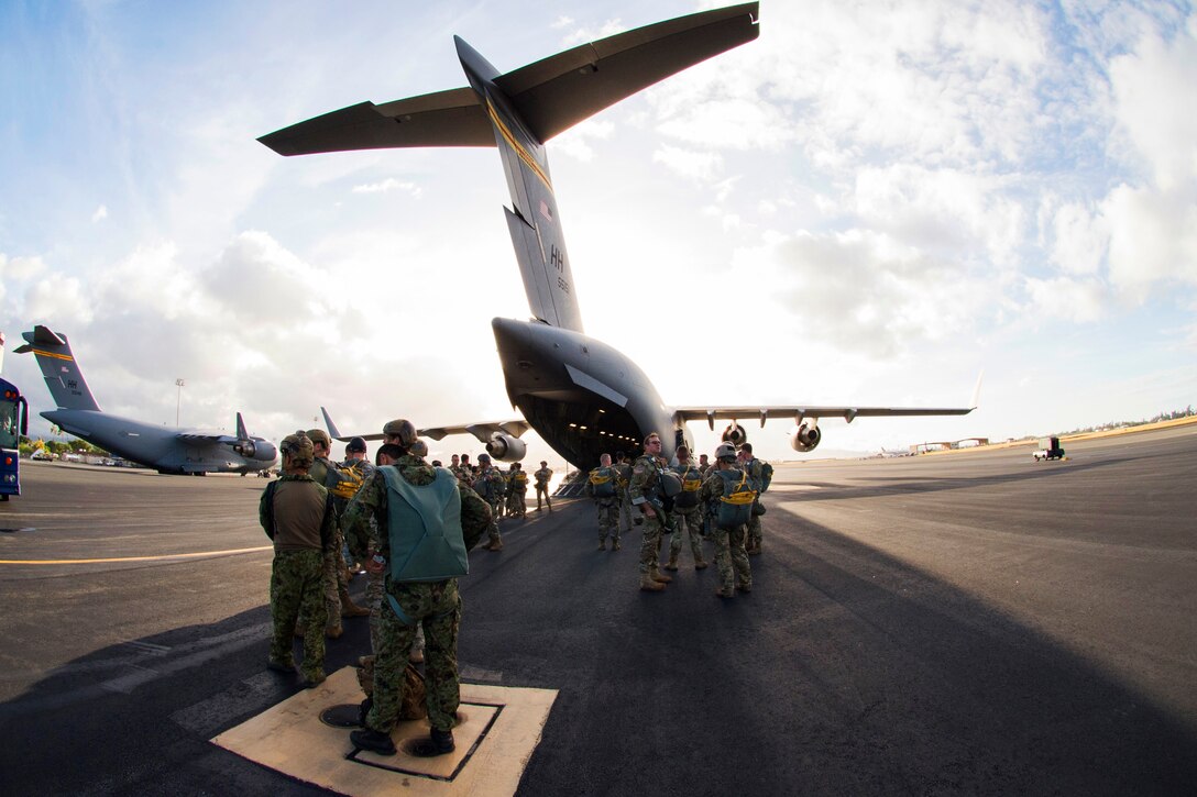 Service members prepare to board a C-17 Globemaster III cargo aircraft for airborne operations training.