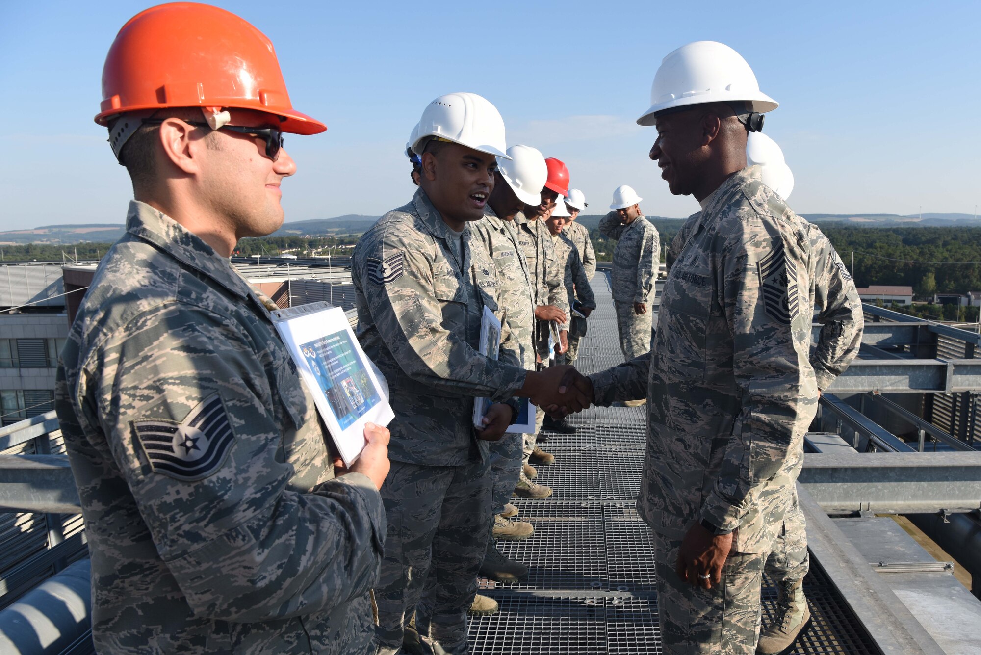 Chief Master Sgt. of the Air Force Kaleth O. Wright shakes hands with Tech. Sgt. Ronnoah Buniag, 86th Logistics Readiness Squadron noncommissioned officer in charge of individual protective equipment, June 26, 2018 on Ramstein Air Base, Germany. Wright received briefings that morning on several innovations and future plans for the base.