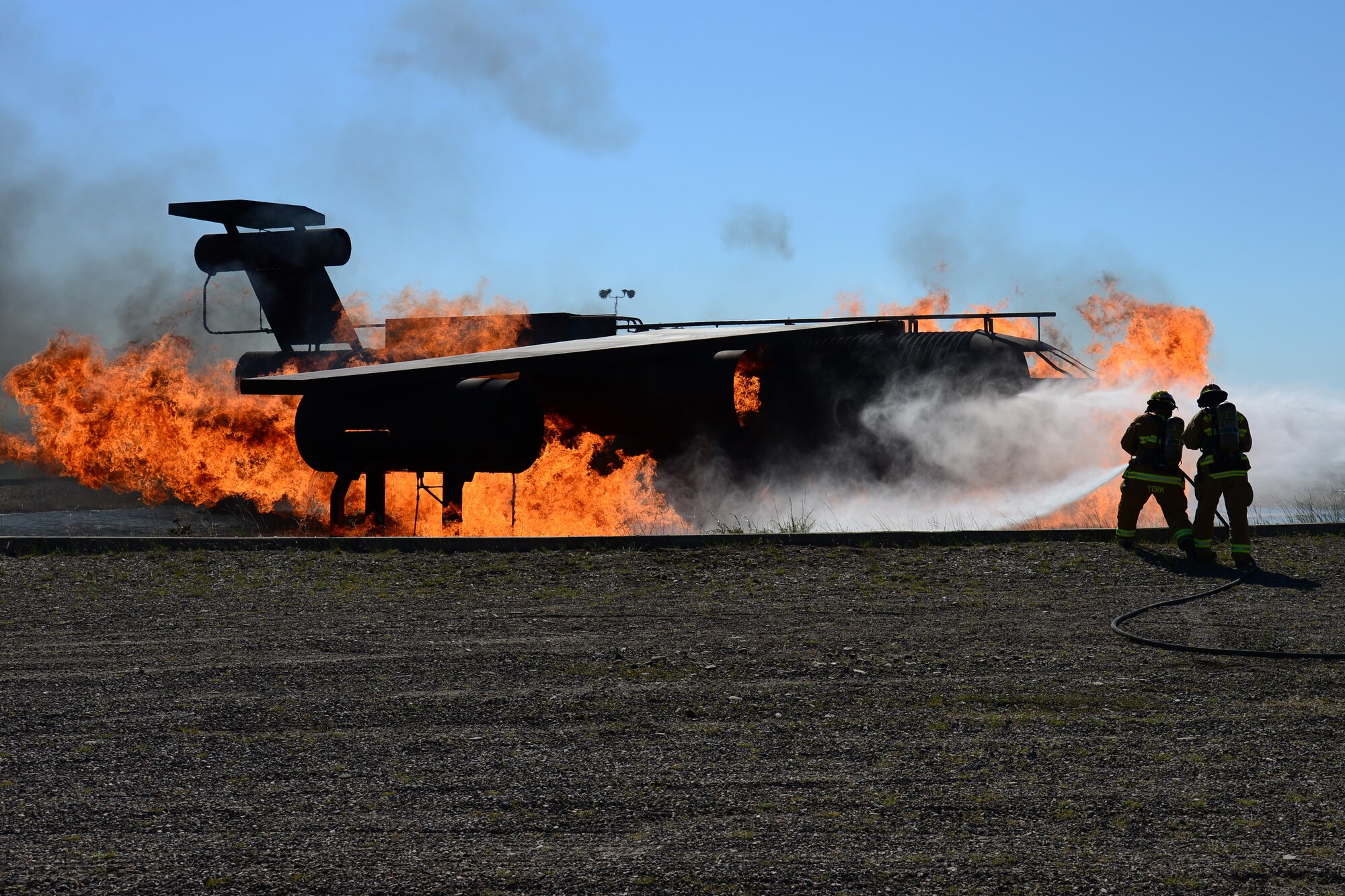 Airman 1st Class Dean York, left, and Staff Sgt. Peter Kuriwai, 341st Civil Engineer Squadron firefighters, attempt to put out a fire during an exercise July 18, 2018, at Malmstrom Air Force Base, Mont. Airmen with the 341st CES ran through aircraft fire procedures in case a disaster occurs. (U.S. Air Force photo by Airman 1st Class Tristan Truesdell)