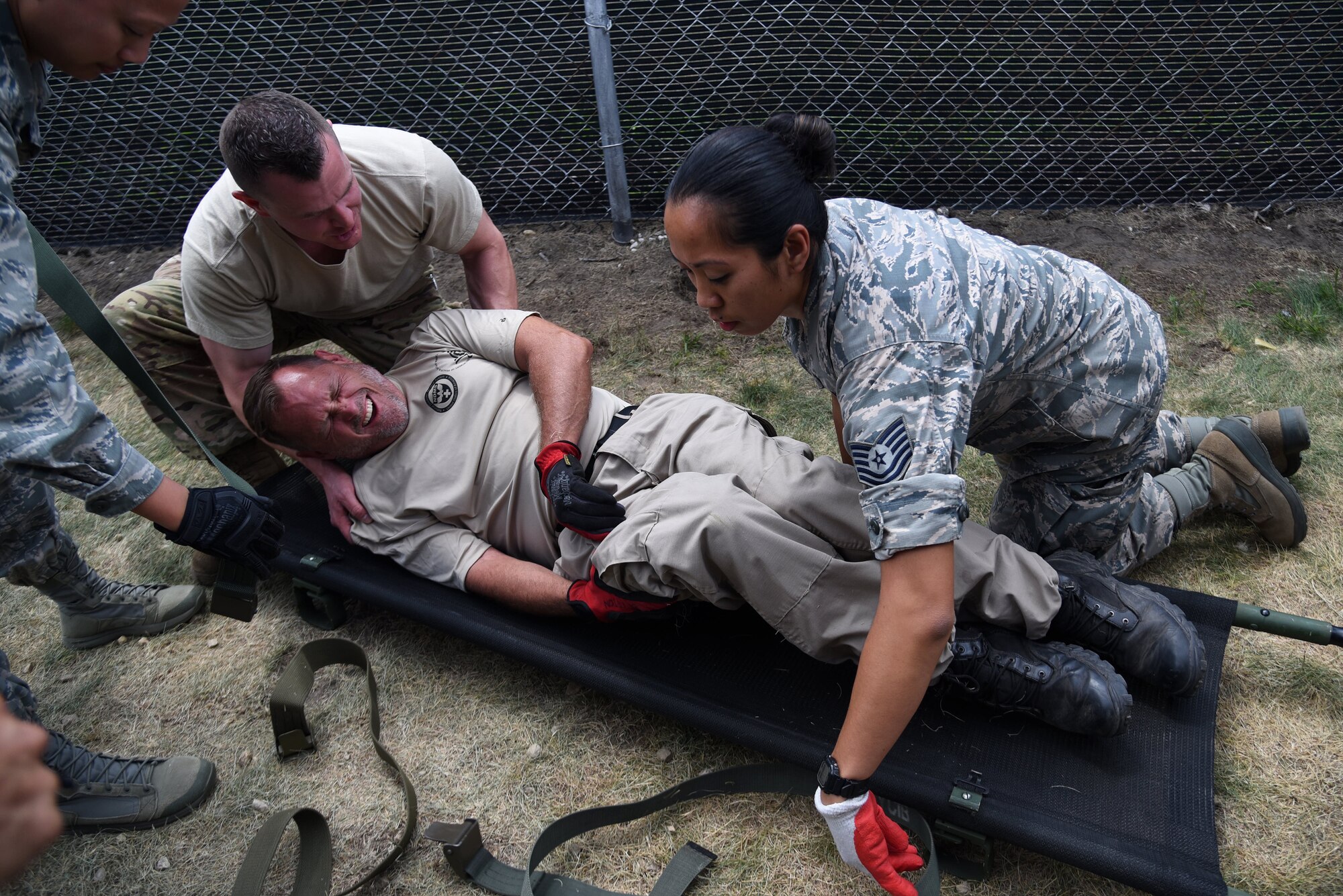 Tech. Sgt. Frank Yuvan, left, an Independent Duty Medical Technician from the 421st Combat Training Squadron, and Tech. Sgt. Deborah Macalalad, an aerospace medical technician from the 108th Medical Group, put Pete Brierton, Disaster Medical Assistance Team medic, onto a litter during Patriot North 18 at Volk Field, Wis., July 18, 2018. Patriot is a domestic operations disaster-response training exercise conducted by National Guard units working with federal, state and local emergency management agencies and first responders. (U.S. Air National Guard photo by Senior Airman Julia Santiago)