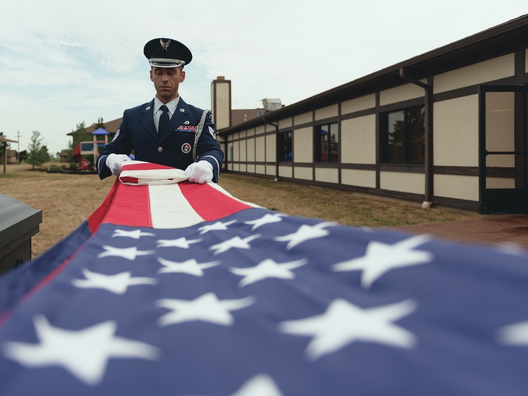 Tech. Sgt. Christopher Mckimmie, a paralegal specialist, and Tech. Sgt. Philip Depronio, an admin specialist, assigned to the 107th Attack Wing, New York National Guard, train on the flag folding portion of funeral honors, Niagara Falls Air Reserve Station, N.Y., July 24, 2018. The triangle folds and all movements involved must be done with precision in order for the flag to be presentable to the next of kin during a service. (U.S. Air National Guard photo by Staff Sgt. Ryan Campbell)