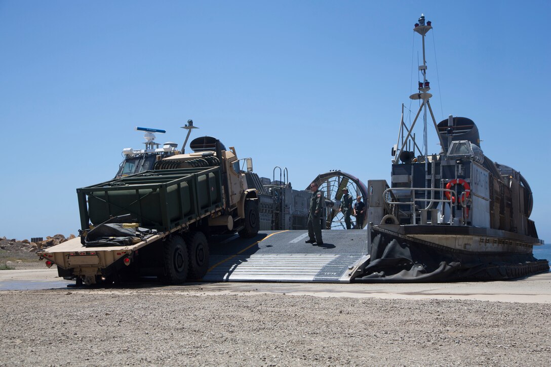 Marines with Marine Wing Support Squadron (MWSS) 373 and Sailors with Assault Craft Unit (ACU) 5 offload vehicles from a landing craft, air cushion in support of Exercise Summer Fury 2018, on San Clemente Island, Calif. July 23. Summer Fury is designed to increase the functionality and effectiveness of 3rd Marine Aircraft Wing while also enhancing Marine Air-Ground Task Force and naval integration with participating I Marine Expeditionary Force and naval units. (U.S. Marine photograph by Cpl. Joshua S. McAlpine/Released)