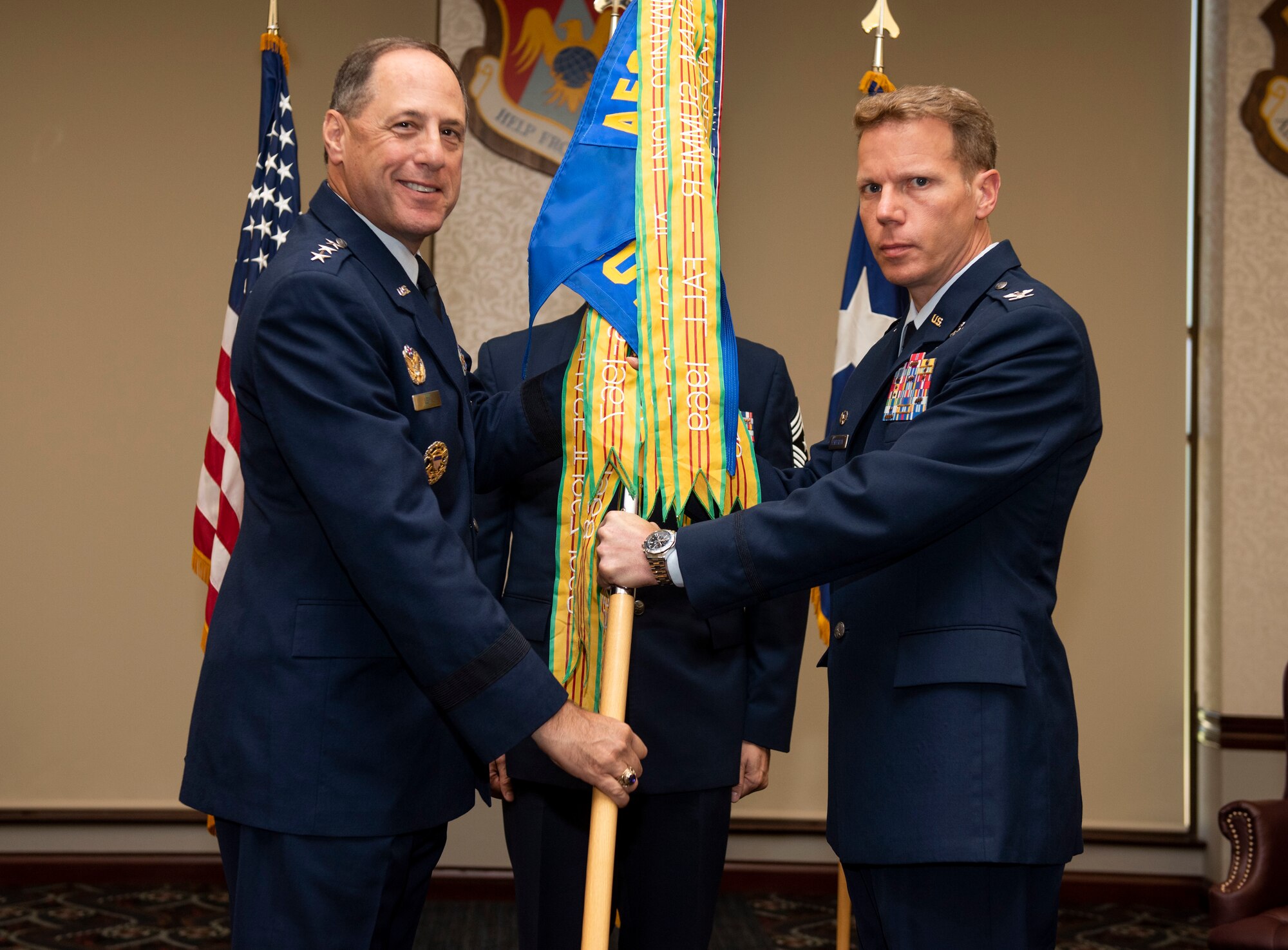 Lt. Gen. Lee Levy II, Air Force Sustainment Command commander, presents the 635th Supply Chain Operations Wing guidon to Col. Robert Henderson