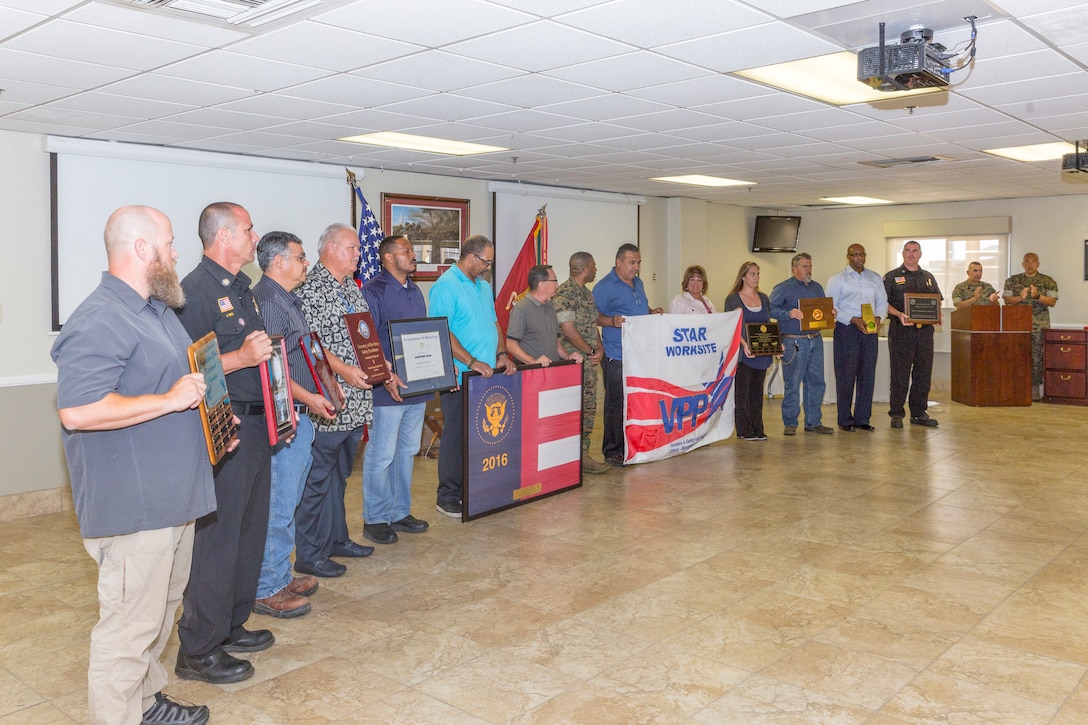 Civilian employees of Marine Corps Logistics Base Barstow present Col. Sekou Karega, MCLB Barstow base commander, with various awards the installation has earned during the command during the quarterly awards breakfast aboard MCLB Barstow, Calif., July 17.