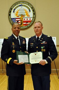 Brig. Gen. Aaron R. Dean, II, adjutant general, District of Columbia National Guard, presents Warrant Officer Jonathan Callaway with an Army Commendation Medal during a reception celebrating 100 years of the U.S. Army warrant officer corps, on Feb. 27, in the Commanding General’s Conference Room of the D.C. Armory, in Washington, D.C. Callaway was presented the award for being the distinguished honor graduate in his Army rotary wing pilot course. (U.S. Army National Guard photo and caption by Spc. Kevin Valentine/released)