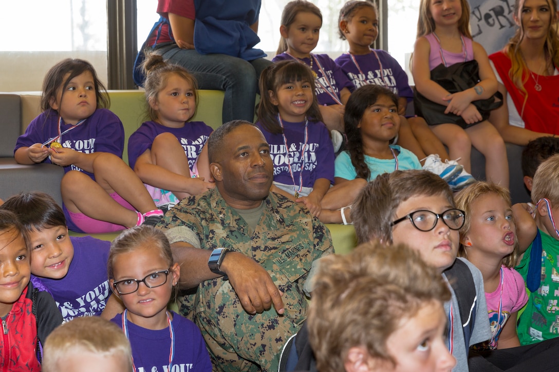 Col. Sekou S. Karega, MCLB Barstow base commander, sits among the Summer Reading Program participants while listing to a story being read.