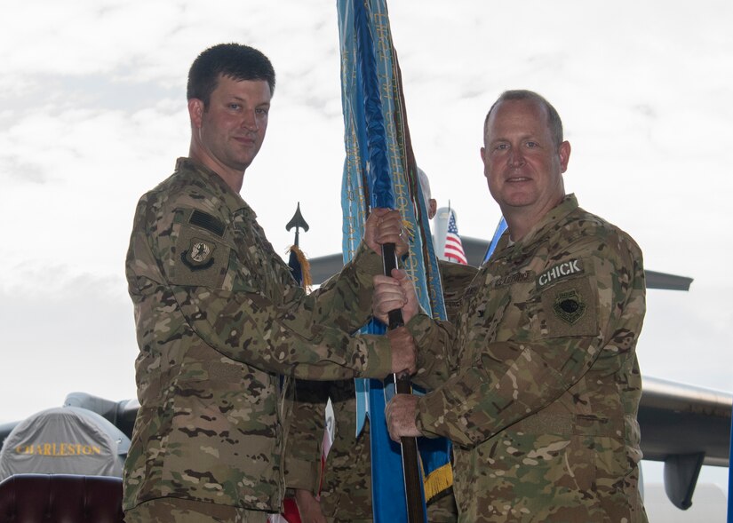 Col. Louis Hansen, right, 437th Operations Group outgoing commander, relinquishes the 437th OG guidon to Col. Clint R. ZumBrunnen, left, 437th Airlift Wing commander, during a change of command ceremony July 27, 2018, in Nose Dock 2.