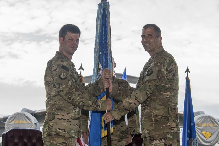 Col. Daniel Dobbels, right, 437th Operations Group incoming commander, accepts the 437th OG guidon from Col. Clint R. ZumBrunnen, left, 437th Airlift Wing commander, during a change of command ceremony July 27, 2018, in Nose Dock 2.