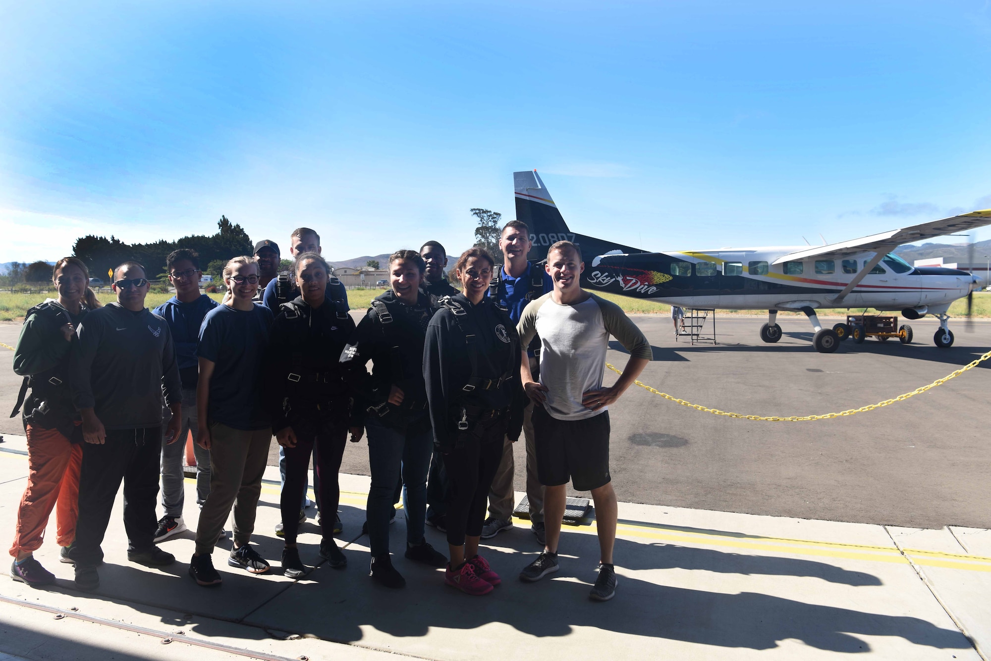 Participants of the Leap of Faith event smile eagerly prior to their jump July 21, 2018 at Skydive Santa Barbara, Lompoc, Calif. All 12 participants attended this event to learn more about faith and how to release themselves from anything holding them back in life. (U.S. Air Force photo by Airman First Class Aubree Milks/Released)