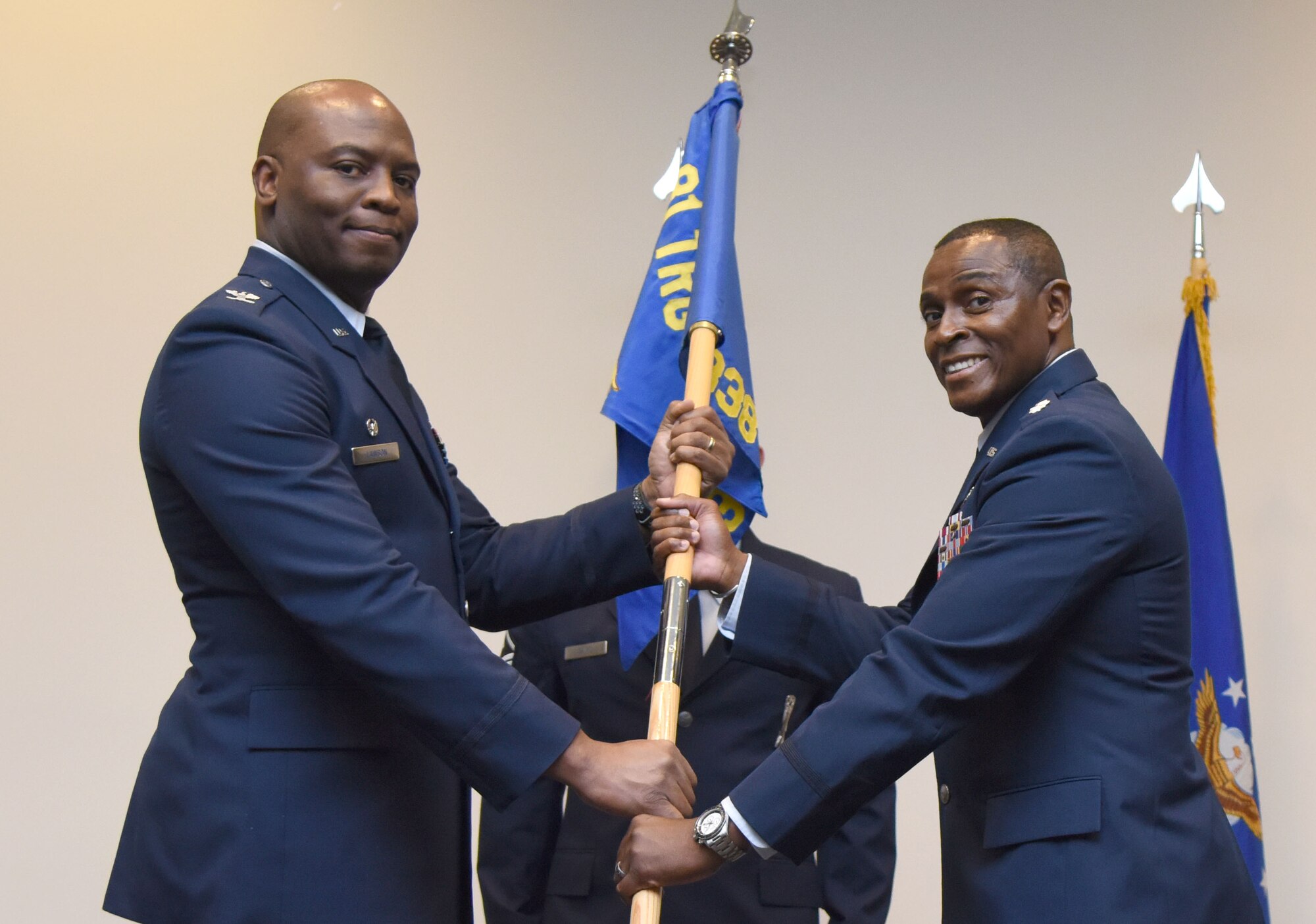 U.S. Air Force Col. Leo Lawson, Jr., 81st Training Group commander, passes the 338th Training Squadron guidon to Lt. Col. Andre Johnson, incoming 338th TRS commander, during the 338th TRS change of command ceremony in the Roberts Consolidated Aircraft Maintenance Facility at Keesler Air Force Base, Mississippi, July 26, 2018. The passing of the guidon is a ceremonial symbol of exchanging command from one commander to another. (U.S. Air Force photo by Kemberly Groue)