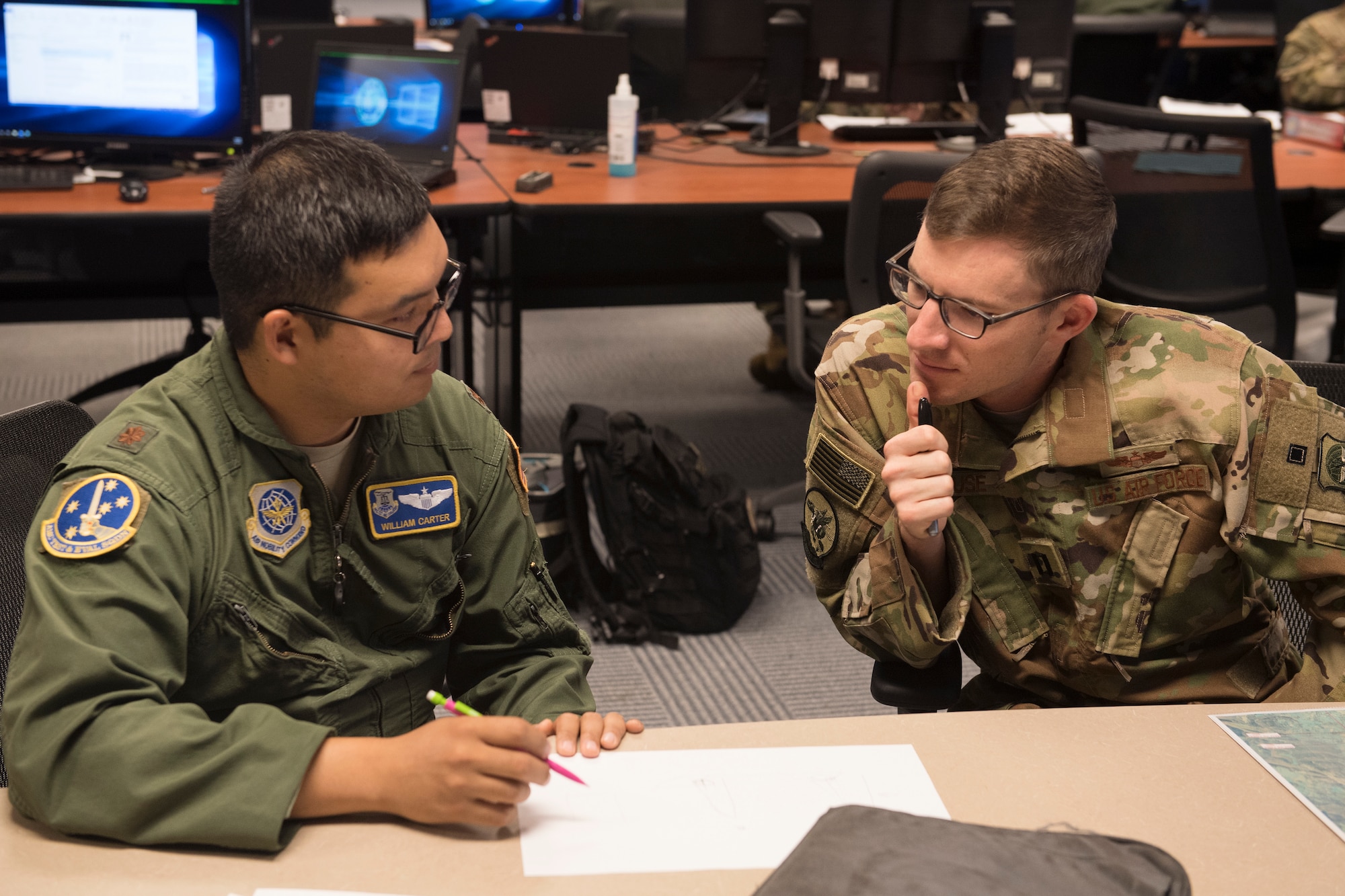 Maj. William Carter, Air Mobility Command Test and Evaluation Squadron Pilot-Directed Airdrop test Test Director, conducts preflight planning July 19, 2018, with Capt. Nick Krause, a pilot from the 8th Airlift Squadron at Joint Base Lewis-McChord, Wash.