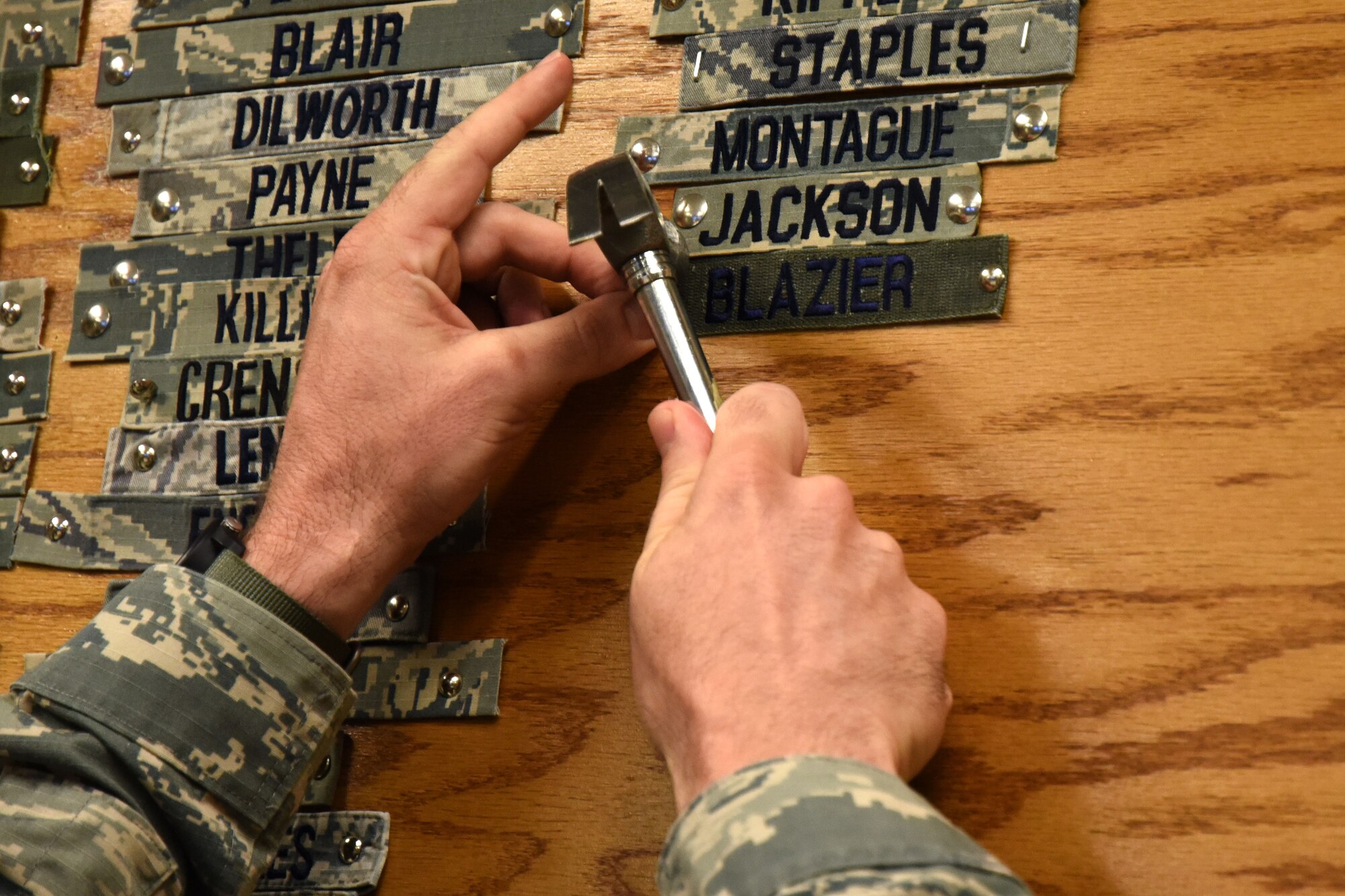 U.S. Air Force Chief Master Sgt. Stefan Blazier, 363rd Intelligence, Surveillance and Reconnaissance Wing command chief, tacks his name tape to the instructor wall in the Heritage Hall of the 315th Training Squadron on Goodfellow Air Force Base, Texas, July 26, 2018. This hall is used to honor instructors who have taught at the squadron over the years. (U.S. Air Force photo by Airman 1st Class Seraiah Hines/Released)
