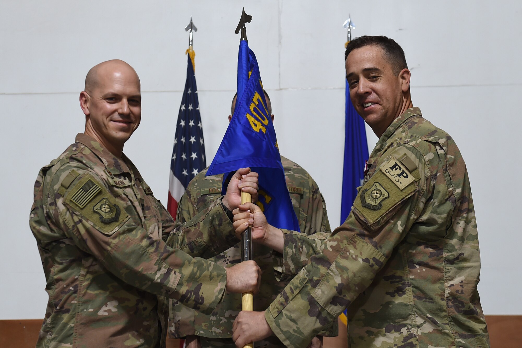 Two Airmen hold on to squadron flag