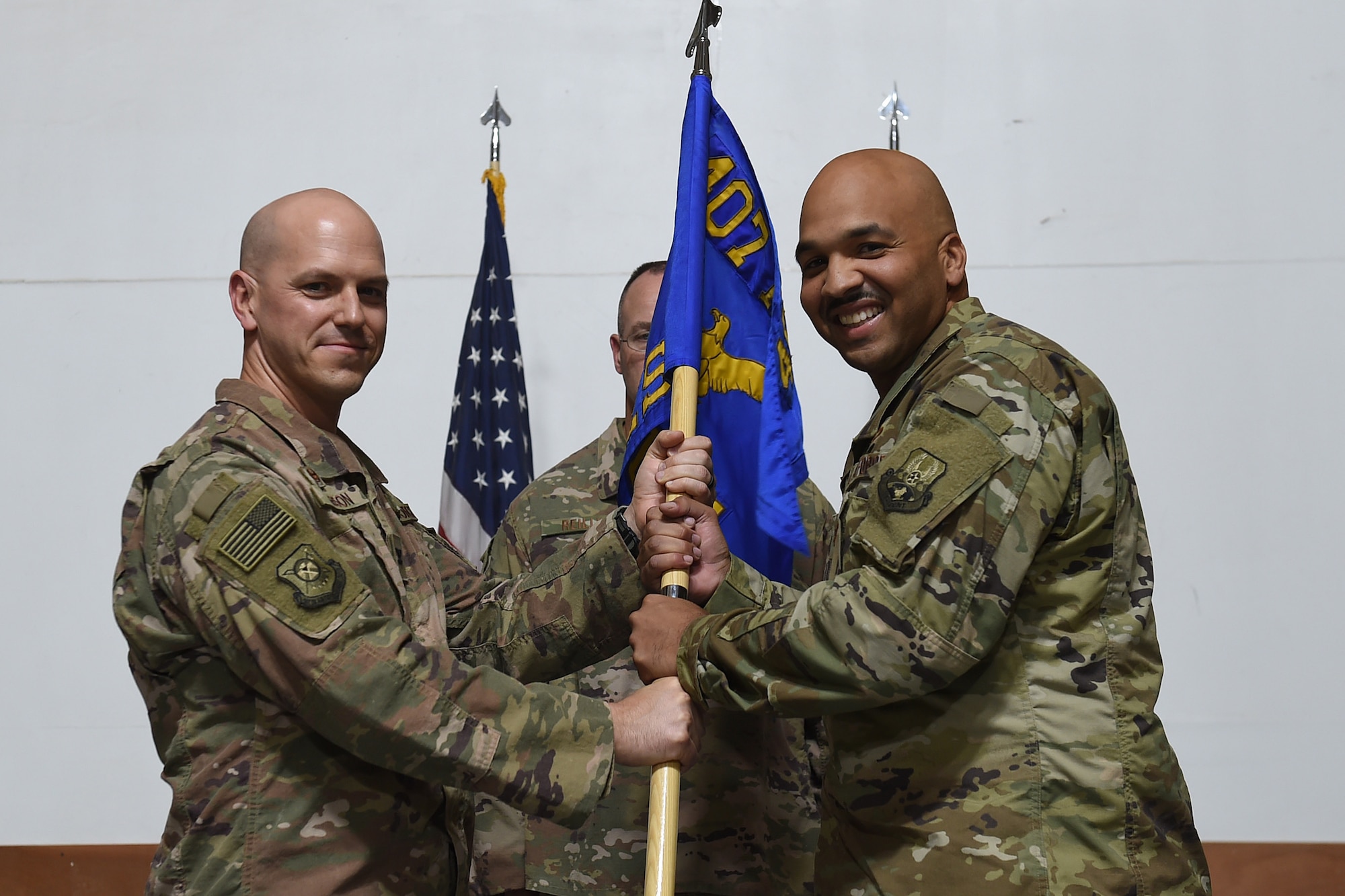 Two Airmen hold on to squadron flag