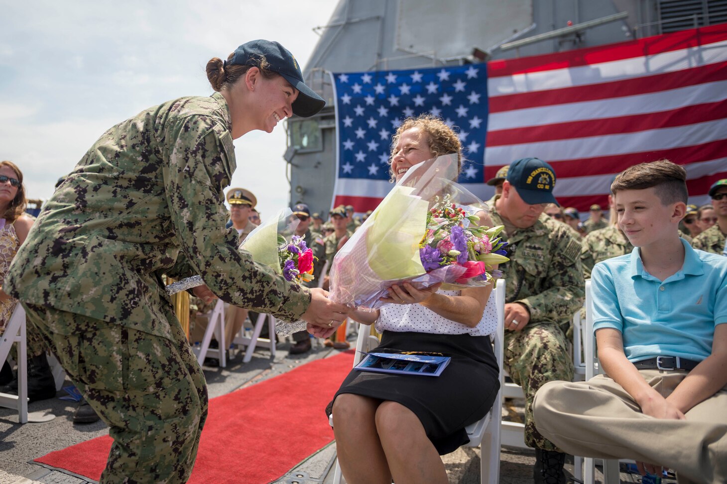 YOKOSUKA, Japan (July 27, 2018) Ensign Julianne Dahlman gives flowers to the wife of the newly appointed commanding officer of the Ticonderoga-class guided-missile cruiser USS Chancellorsville (CG 62) on the ship’s flight deck during a change of command ceremony where Capt. Wilson Marks is relieved by Capt. Marc D. Boran as the ship’s commanding officer. Chancellorsville is forward-deployed to the U.S. 7th Fleet area of operations in support of security and stability in the Indo-Pacific region. (U.S. Navy photo by Mass Communication Specialist 2nd Class Sarah Myers/Released)