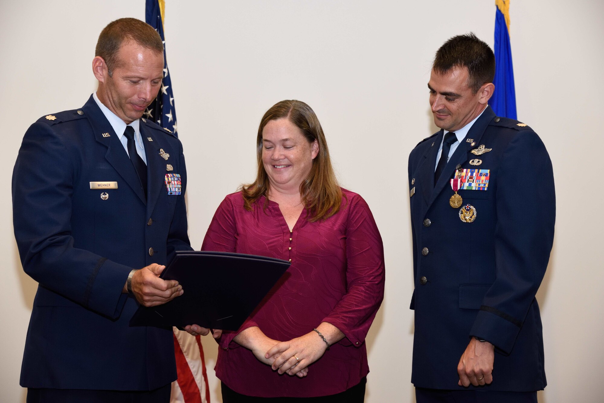 Lt. Col. (retired) Matthew Wehner (left) gives a spouse’s appreciation certificate to Megan Rubio, wife of Lt. Col. Stuart M. Rubio (right), commander of the Air Force Reserve’s 815th Airlift Squadron “Flying Jennies” during Lt. Col. Rubio’s retirement ceremony held July 28, 2018, at the Roberts Consolidated Maintenance Facility, Keesler Air Force Base, Mississippi. Rubio, an active-duty C-130 pilot who has been commander of the Flying Jennies since February of 2016, will still continue to serve as commander of the squadron, but instead as a reservist as part of the Regular Air Force to Air Force Reserve Program. (U.S. Air Force photo by Tech. Sgt. Ryan Labadens)