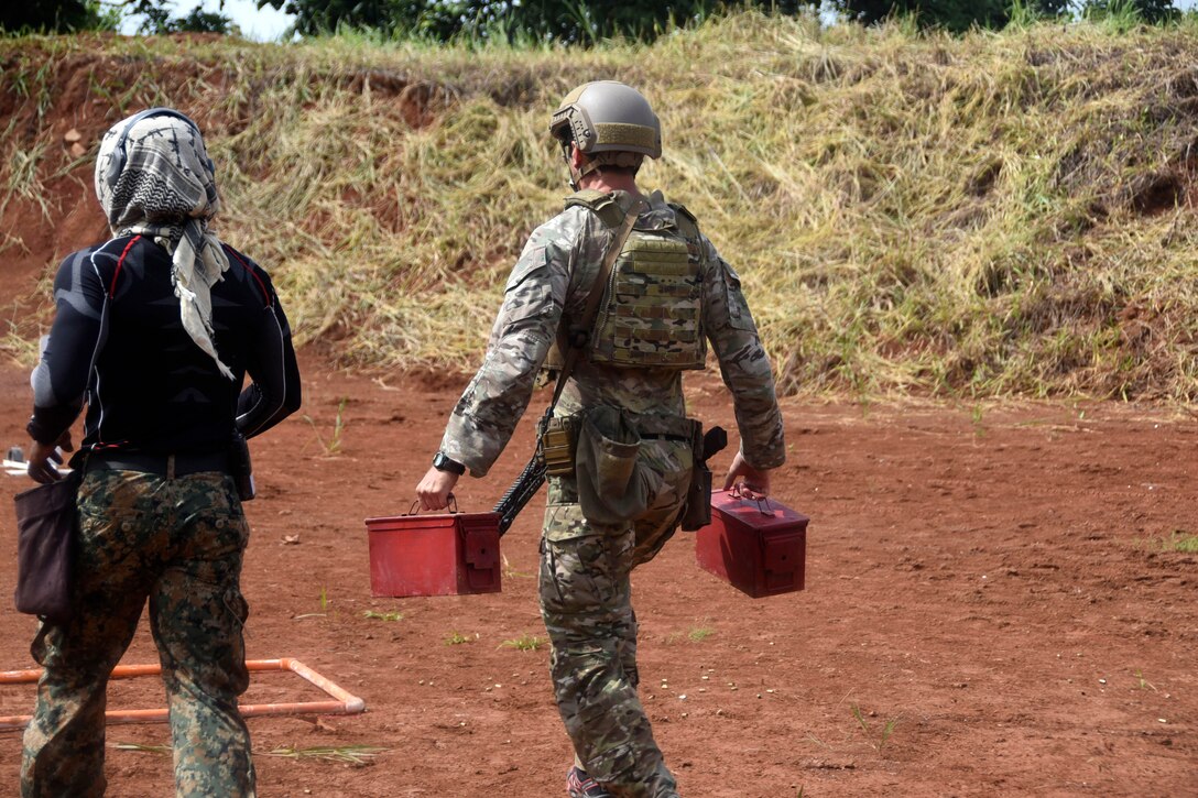 A U.S. Army Green Beret carries weighted ammo cans during a portion of a stress test.