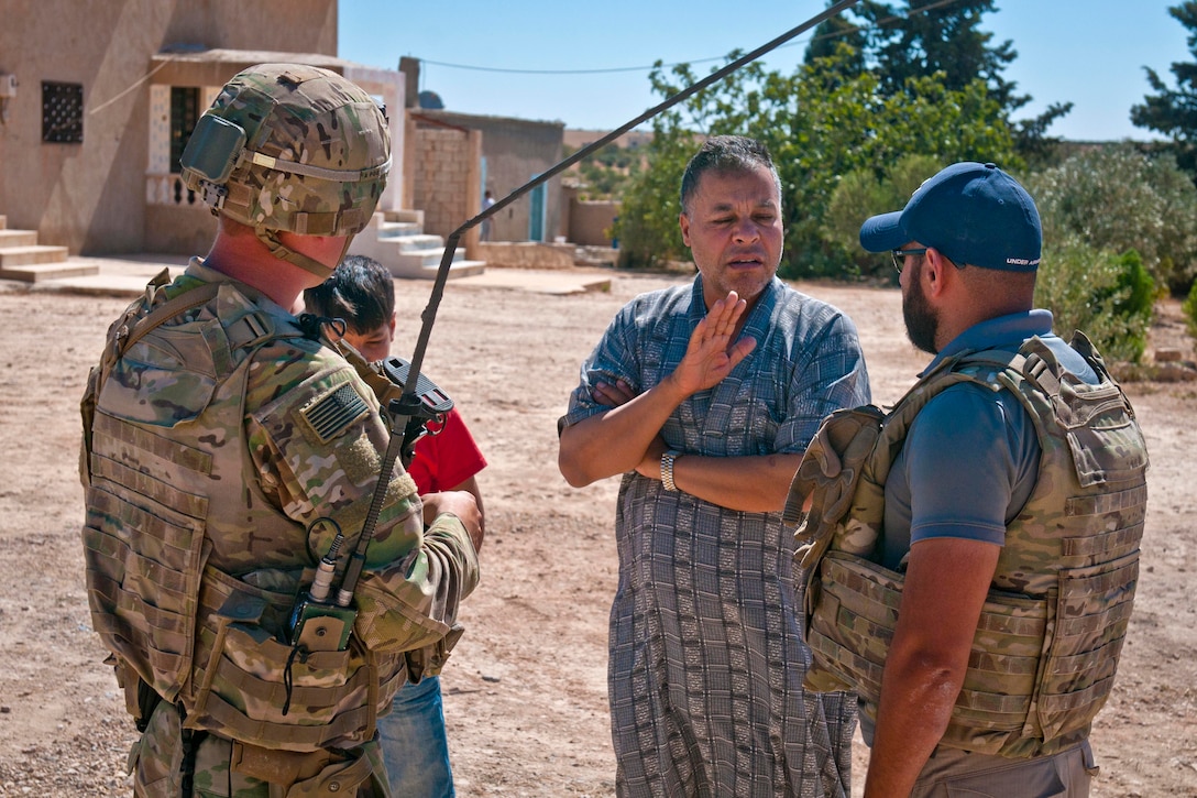 A U.S. soldier and an interpreter talk with local villagers.