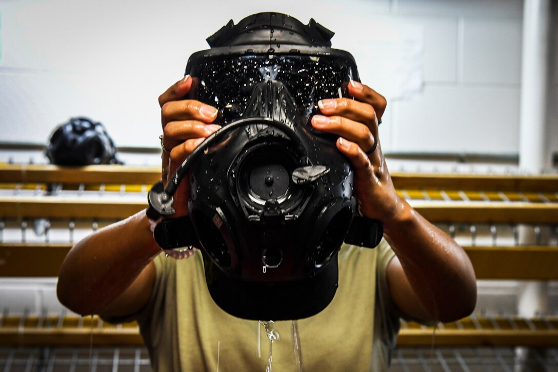 Air Force airman continues the process of rinsing gas masks for the next cycle of soldiers.