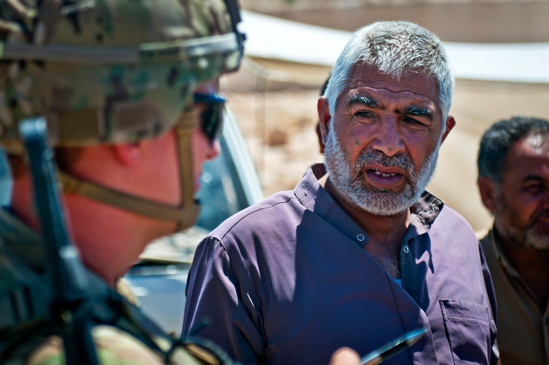 A soldier talks with a local villager during a patrol.