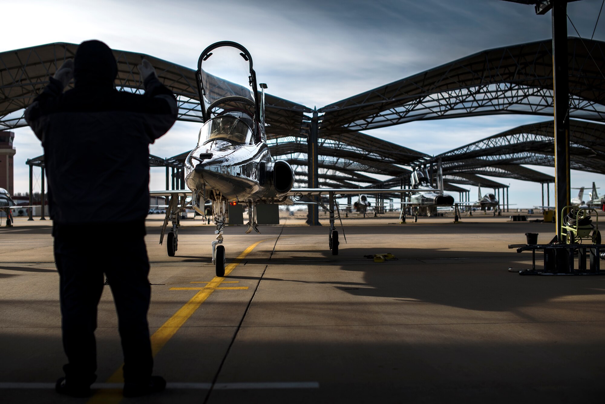 An L3 Maintenance contractor directs a T-38C Talon to its parking spot Feb. 1, 2018, at Vance Air Force Base, Oklahoma. The T-38 is a two-seat, twinjet supersonic jet trainer. It was the world's first supersonic trainer and is also the most produced. (U.S. Air Force photo by Senior Airman Corey Pettis)