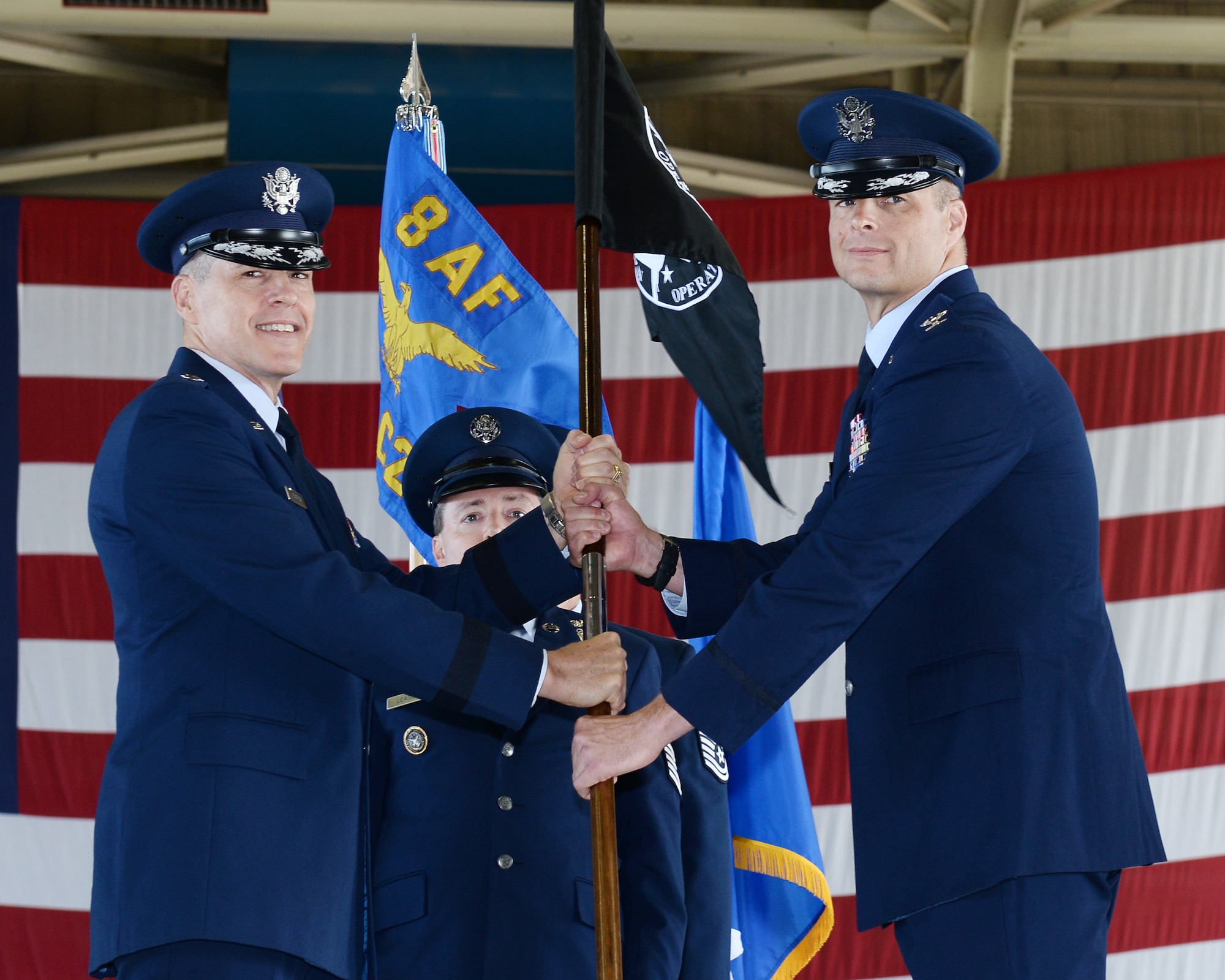 U.S. Air Force Maj. Gen. Thomas Bussiere, Eighth Air Force and Joint-Global Strike Operations Center commander (left)  presents the National Airborne Operations Center guidon to U.S. Air Force Jeremiah Baldwin, incoming 595th C2G commander and NAOC commander (right), during the dual-595th Command and Control Group and National Airborne Operations Center change of command ceremony July 27, 2018, at Offutt Air Force Base, Nebraska as a single commander assumed responsibility for both organizations. Passing of the guidon is a time-honored military tradition signifying the transfer of command to an incoming commander. (U.S. Air Force photo by Charles Haymond)