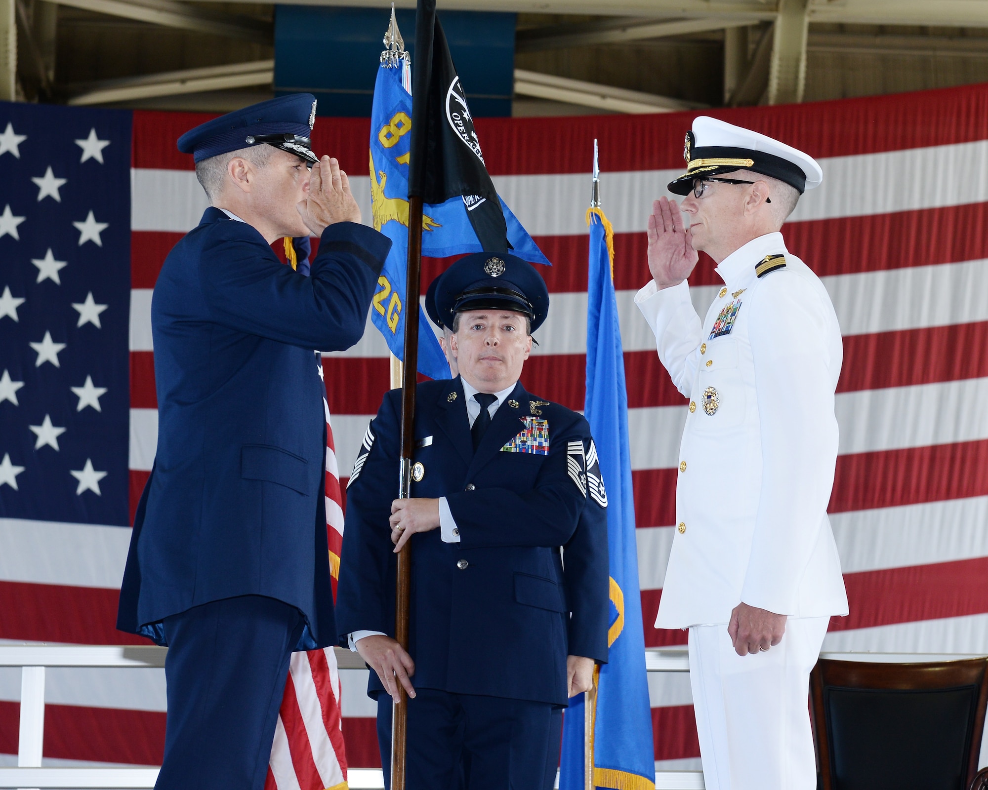 U.S. Air Force Maj. Gen. Thomas Bussiere, Eighth Air Force and Joint-Global Strike Operations Center commander (left) and U.S. Navy Capt. Dennis Crews, outgoing NAOC commander (right), exchange salutes during the dual-595th Command and Control Group and National Airborne Operations Center change of command ceremony July 27, 2018, at Offutt Air Force Base, Nebraska as a single commander assumed responsibility for both organizations. (U.S. Air Force photo by Charles Haymond)