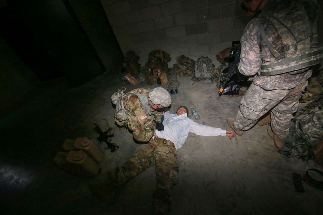 Soldiers search a mock enemy combatant during air assault training.