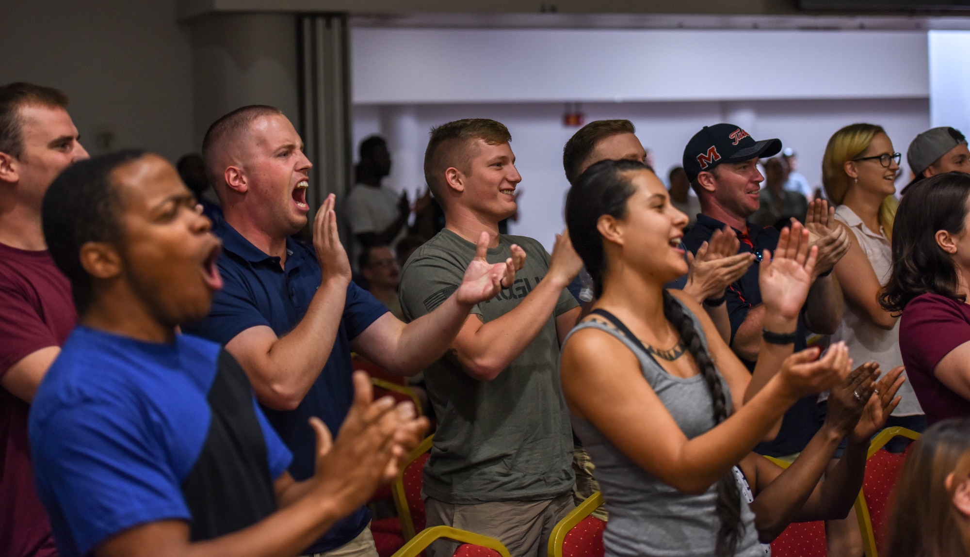 Airmen in a crowd cheer on a contestant at the men’s bodybuilding category during the Clash of the Titans competition at Incirlik Air Base, Turkey, 2018