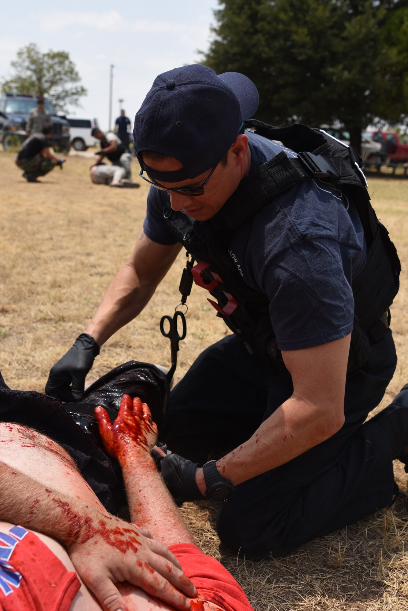 17th Civil Engineer Squadron Assistant Fire Chief, Jason Garcia, readies a tourniquet for simulated wounds during a Tactical Combat Casualty Care Course near building 3070 on Goodfellow Air Force Base, Texas, July 27, 2018. Garcia and other firefighters practiced lifesaving procedures during an active shooter training exercise. (U.S. Air Force photo by Staff Sgt. Joshua Edwards/Released)