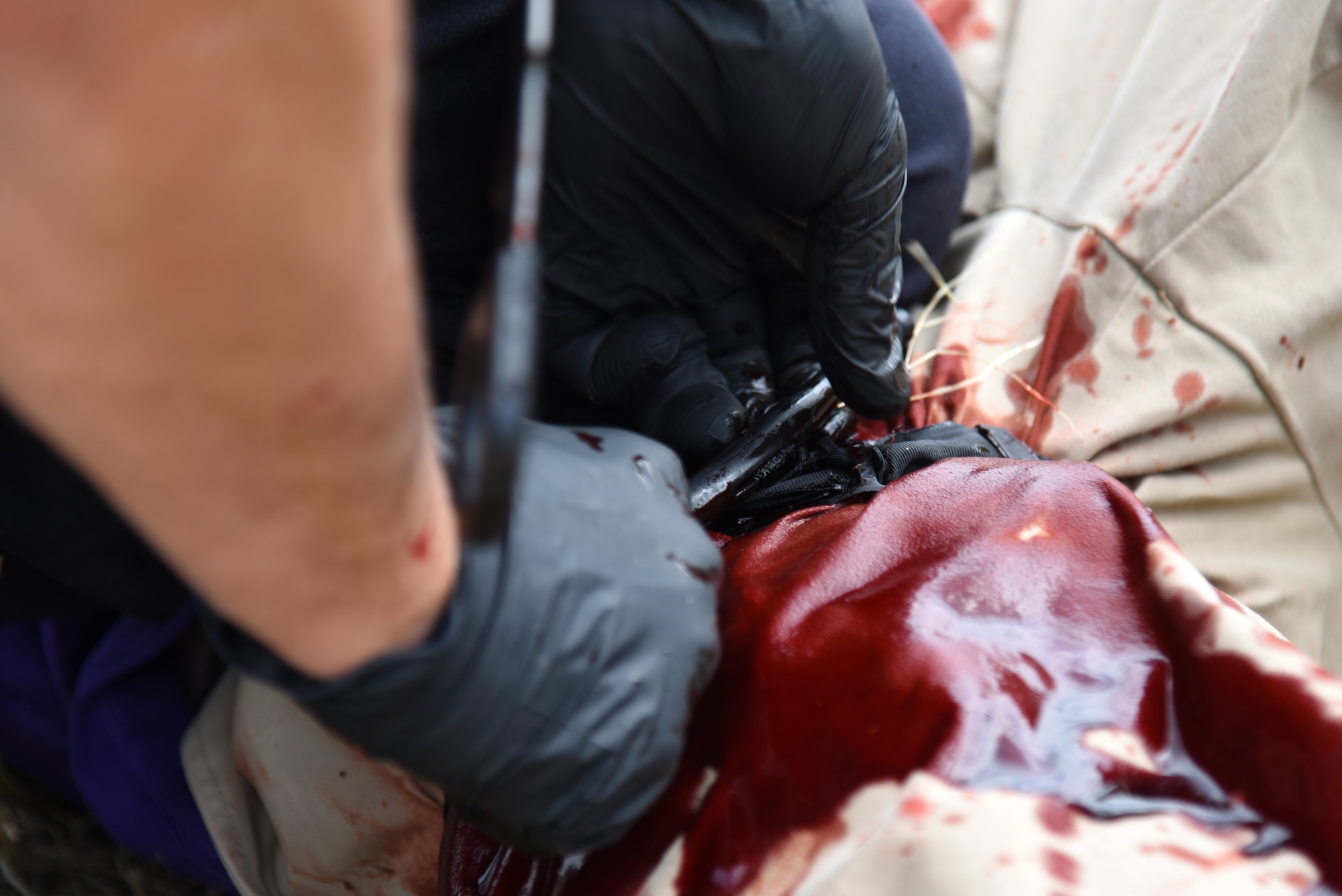 A firefighter applies a tourniquet to a simulated wound during a Tactical Combat Casualty Care Course near building 3070 on Goodfellow Air Force Base, Texas, July 27, 2018. The National Association of Emergency Medical Technicians accredited the TCCC Course and upon completion, each student received certification. (U.S. Air Force photo by Staff Sgt. Joshua Edwards/Released)