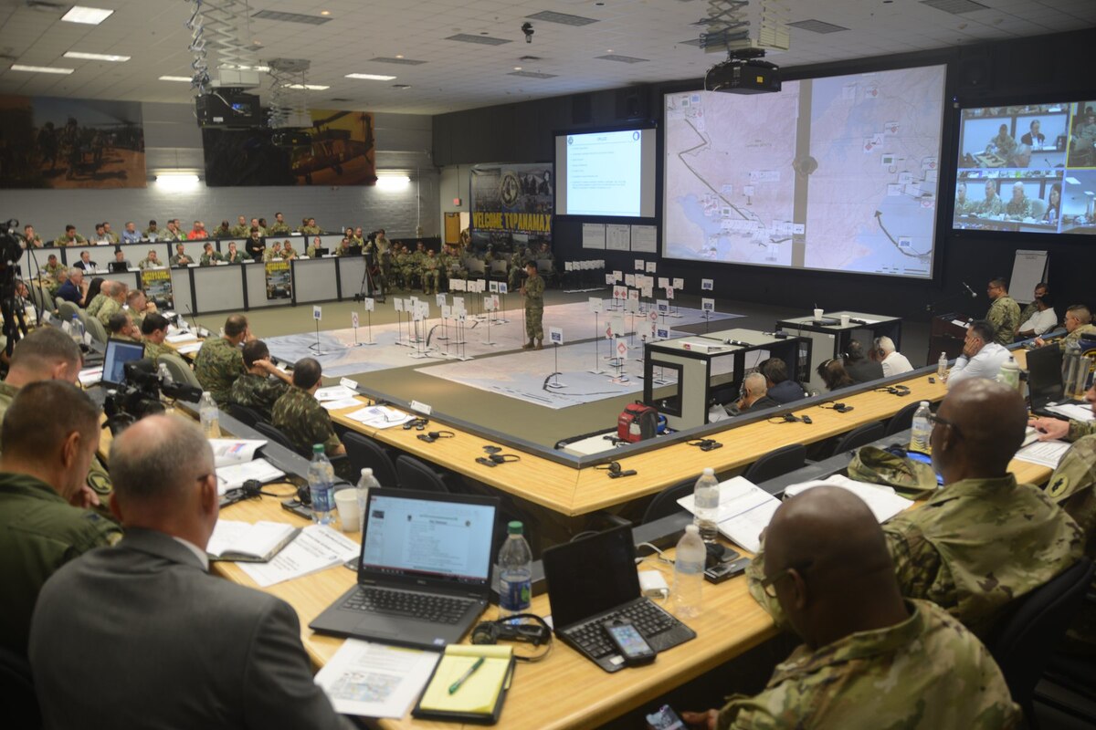 Military leaders gather in a large room.