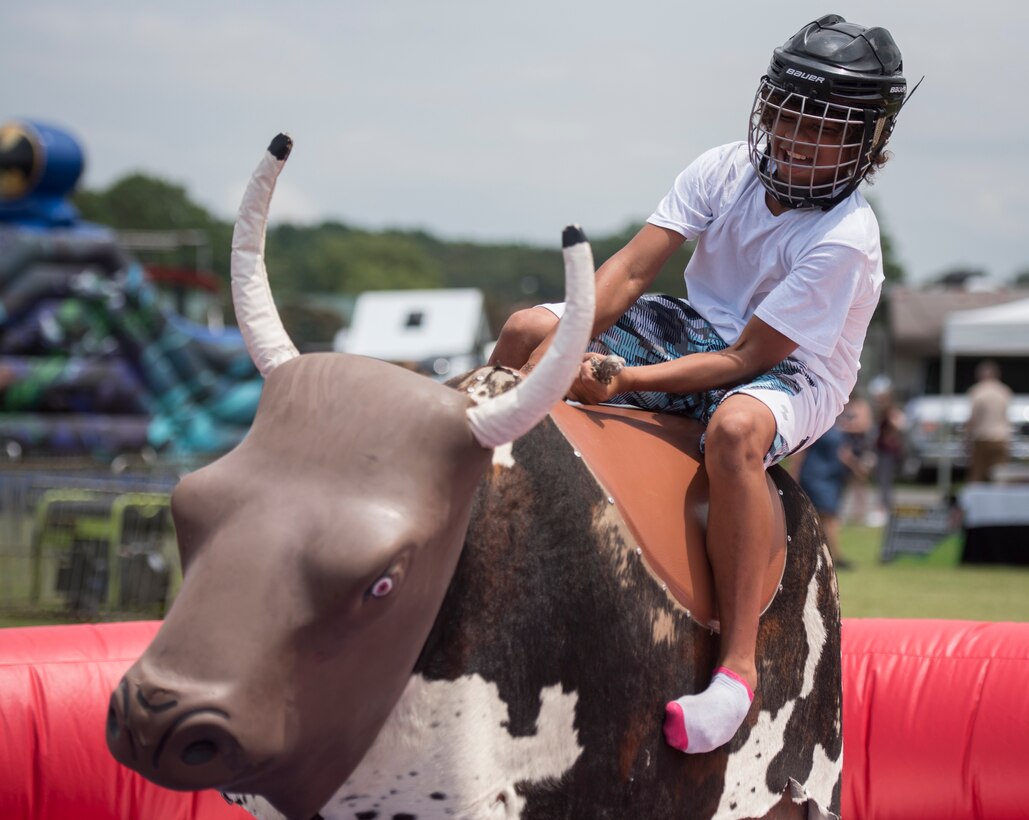 A Fort Eustis 100th Anniversary Open House attendee rides a mechanical bull at Joint Base Langley-Eustis, Virginia, July 28, 2018.