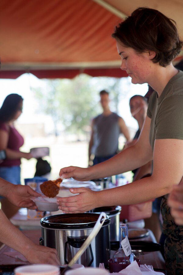 U.S. Marine Corps Lance Cpl. Amber Mock, S-3 Training Clerk, serves a bowl of her Chili during the Headquarters and Headquarters Squadron “Chili Cook-Off and three point shootout” at Marine Corps Air Station Miramar, Calif., July 27.  The event was hosted by the H&HS as part of the monthly “Warrior Challenge” competition, bringing the unit together through various events throughout the year.