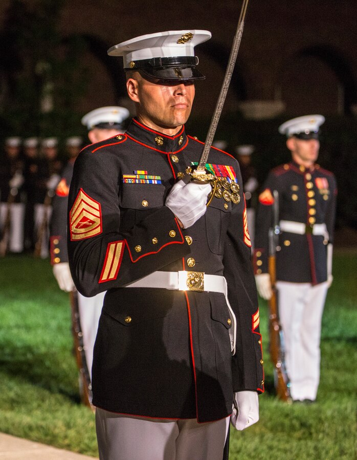 Gunnery Sgt. Michael Charneske, platoon sergeant, U.S. Marine Corps Silent Drill Platoon, renders a sword salute during the Staff-Noncommissioned Officer Friday Evening Parade at Marine Barracks Washington D.C., July 27, 2018. During the SNCO Friday Evening Parade, SNCO’s assume the billets of key leaders’ marching positions normally filled by officers and non-commissioned officers. Charneske assumed the position of the SDP Platoon Commander for the Parade.