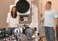 IMAGE: DAHLGREN, Va. (July 10, 2018) - Sarah Wessel and her mentor, Naval Surface Warfare Center Dahlgren Division engineer Matt Henning, examine the Advanced Beam Control Locating and Engaging - Enhanced Tracking System (ABLE-ETS) gimbal. The ABLE ETS Gimbal is part of a pointing and image tracking system. Last summer, Wessel converted the gimbal's pointing controller Simulink code into C++ code. ABLE-ETS is a Joint Technology Office funded test bed for maturing directed energy and high-energy laser technologies, including tracking, sensors, and lasers. 

Wessel is interning at Dahlgren through the STEM (science, technology, engineering and mathematics) Student Employment Program (SSEP). The program provides direct hire authority for undergraduate and graduate degree seeking students enrolled in STEM majors. The program was established to provide interns with exposure to public service, enhance educational experience, and possibly provide financial aid to support educational goals. Additionally, this program will provide a streamlined and accelerated hiring process to compete successfully with private industry for high-quality scientific, technical, engineering, or mathematics students for filling scientific and engineering positions.